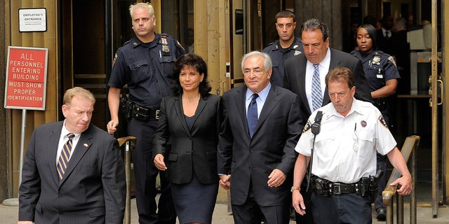 Dominique Strauss-Kahn, center, and his wife, Anna Sinclair, leave the Manhattan Criminal Courthouse after his arraignment hearing on June 6, 2011, in New York City.