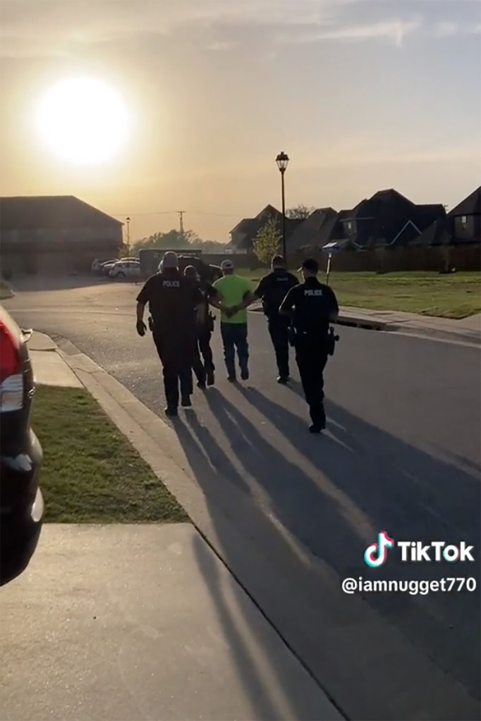 Police escorting sherland to the patrol car.