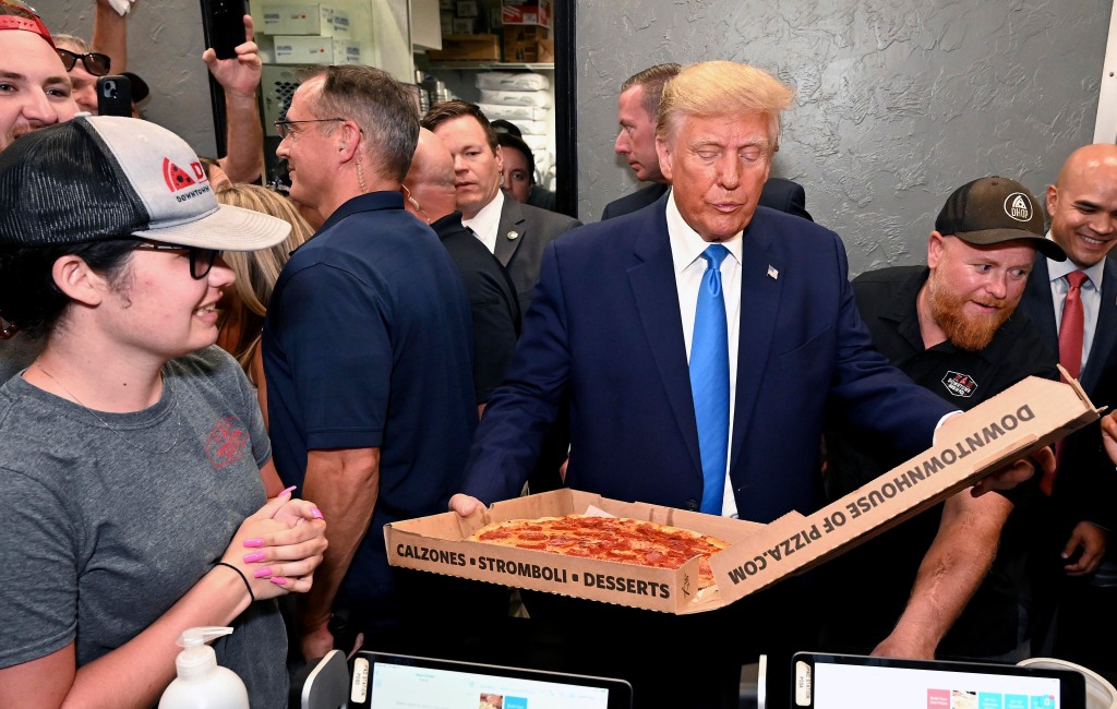 Former President Donald Trump receives his order at Downtown House of Pizza after speaking at the Lee County.