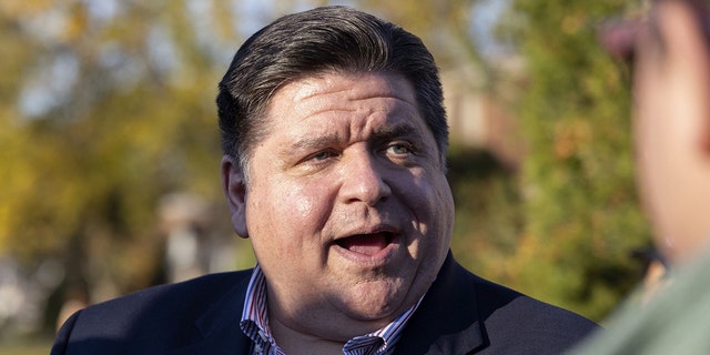 Gov. J.B. Pritzker greets constituents as he campaigns in Bellwood, Illinois, on Nov. 1, 2022. 