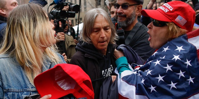 Protesters argue amid the chaotic scene outside the Manhattan courthouse where Trump is expected to be arraigned Tuesday.