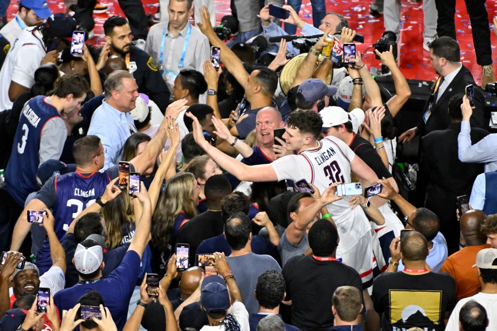 Donovan Clingan #32 celebrates with fans after defeating the San Diego State Aztecs at NRG Stadium on April 3, 2023 in Houston, Texas. 