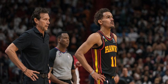 Atlanta Hawks head coach Quin Snyder, left, and Trae Young, #11 of the Atlanta Hawks, during a game against the Miami Heat at Kaseya Center on April 11, 2023 in Miami.