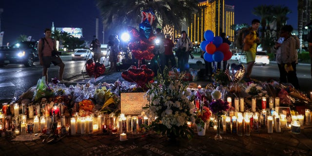 People light candles, place figures and flowers at a makeshift memorial set up along the Las Vegas Strip for the Las Vegas mass shooting victims, who lost their lives after a gunman attack, on Oct. 5, 2017, in Las Vegas.