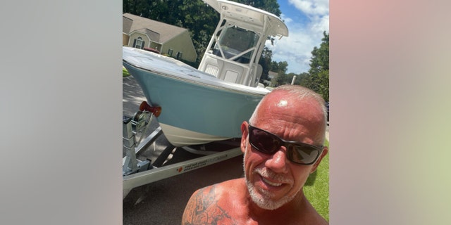 David Hollars poses near a boat