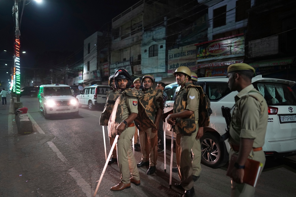 Policemen stand guard outside the crime scene following the shooting of Atiq Ahmad and his brother Ashraf on April 15, 2023. 