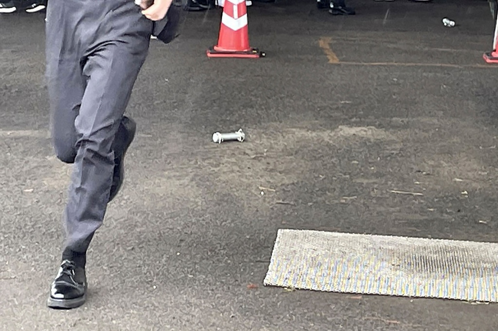 A cylinder-shaped object (C), believed to have been thrown during Prime Minister Fumio Kishida's campaign, is seen on the ground in Wakayama on April 15, 2023.