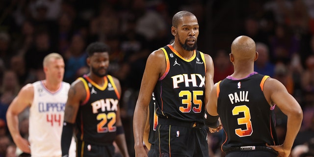 Kevin Durant #35 of the Phoenix Suns talks with Chris Paul #3 during the first half Game One of the Western Conference First Round Playoffs against the LA Clippers at Footprint Center on April 16, 2023 in Phoenix, Arizona.