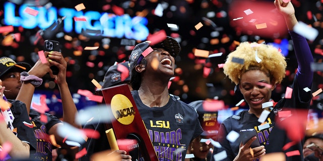 Flau'jae Johnson of the LSU Lady Tigers reacts while holding the championship trophy after defeating the Iowa Hawkeyes 102-85 in the 2023 NCAA Tournament championship game at American Airlines Center April 2, 2023, in Dallas, Texas.