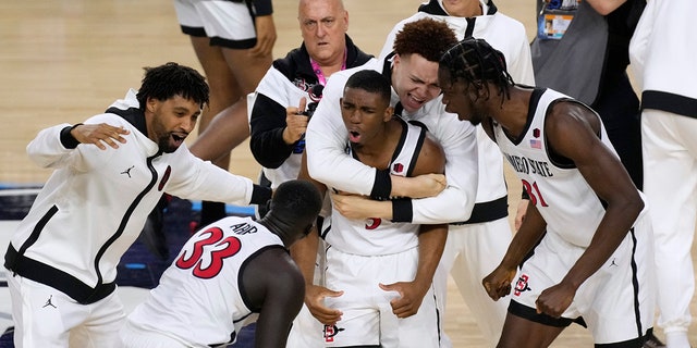 San Diego State guard Lamont Butler, center, celebrates with teammates after he hit the winning basket against Florida Atlantic on Saturday, April 1, 2023, in Houston.