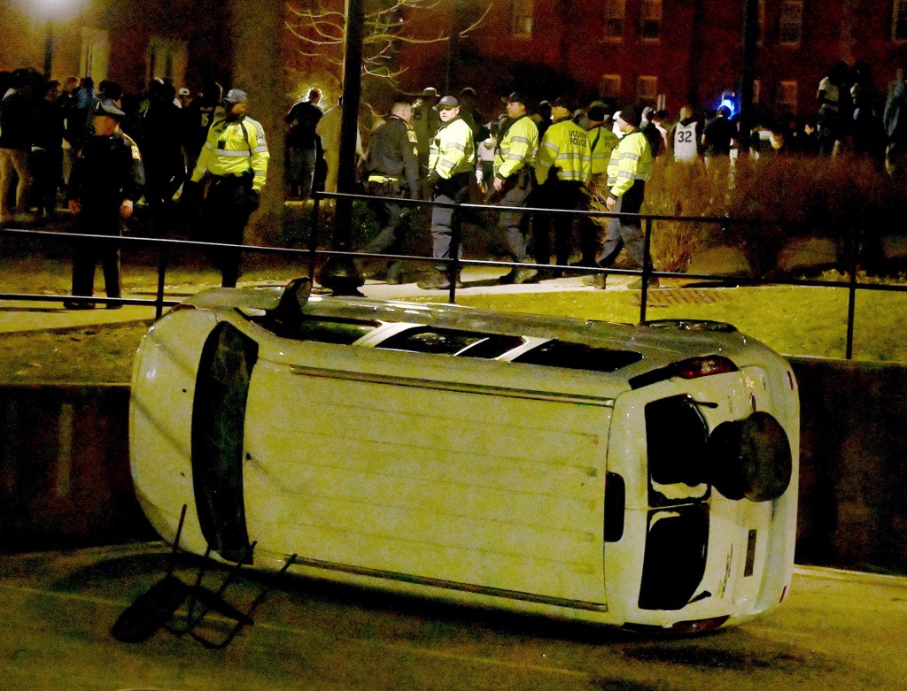 A vehicle is seen overturned as UConn Police and Connecticut State Police try to maintain order on April 4, 2023, in Storrs, Conn. 