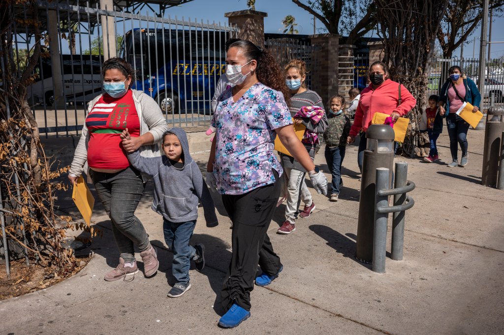 Migrants recently released by U.S. Border Patrol walk to a Catholic shelter after being tested for COVID at a facility in McAllen.