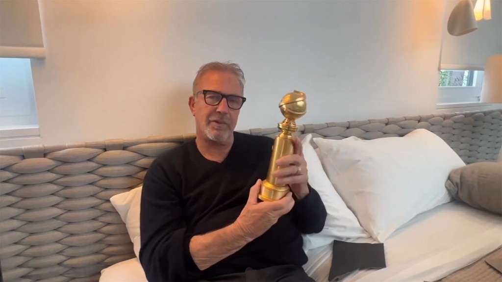 Kevin Costner holding his Golden Globe