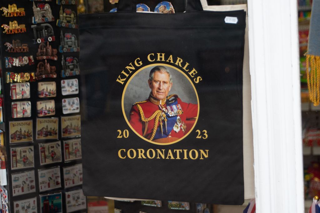 A photo of King Charles in a formal uniform with his  coronation logo on it. 