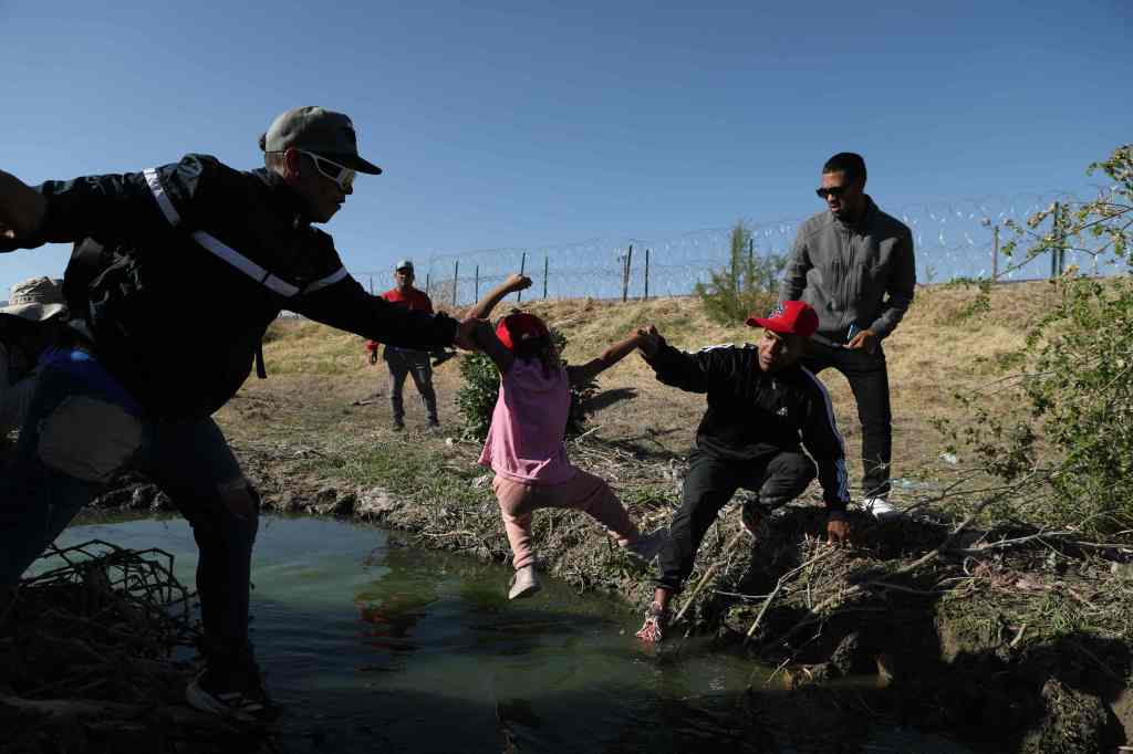 Migrants cross the Bravo river seen from the Mexican side of the US-Mexico border in Ciudad Juarez, Chihuahua state, Mexico, on March 29, 2023.