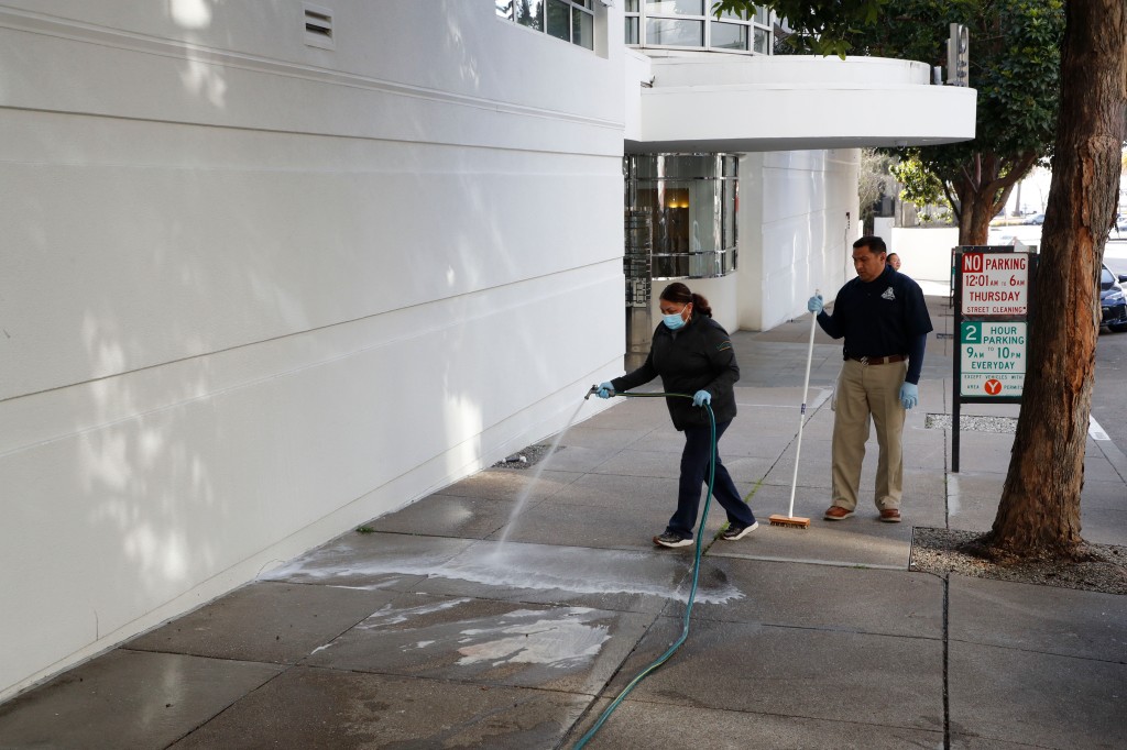 Workers clean the sidewalk area where tech executive Bob Lee was stabbed to death outside of 403 Main Street in San Francisco,