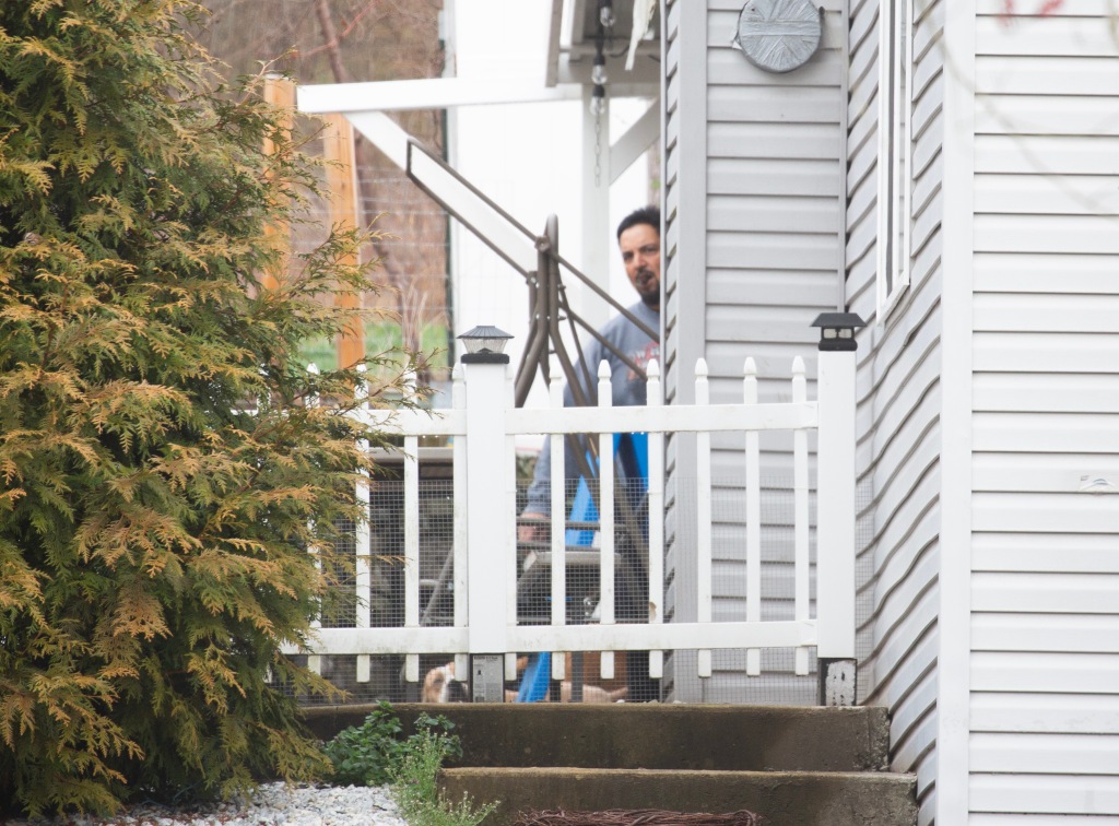 Sajudin outside his home