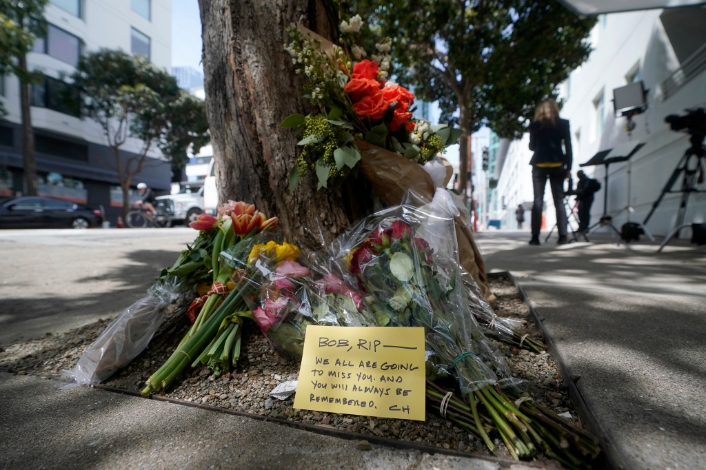 Flowers sit at a tree in front of the building where a technology executive was fatally stabbed outside of in San Francisco, Thursday, April 6, 2023. 