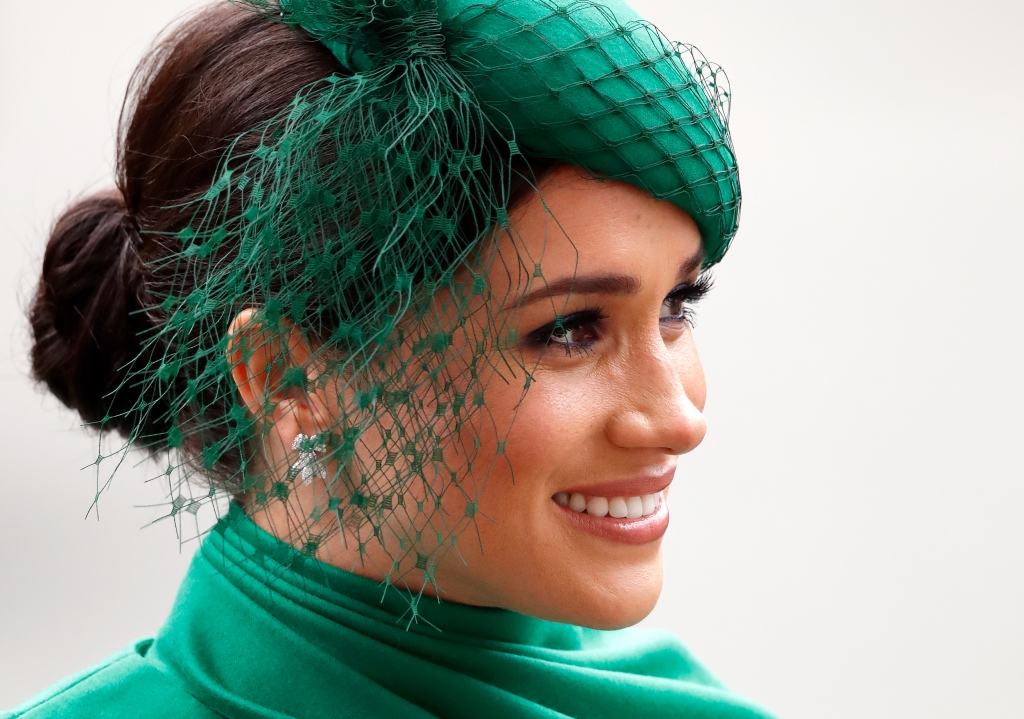 Meghan Markle smiling while wearing green. 