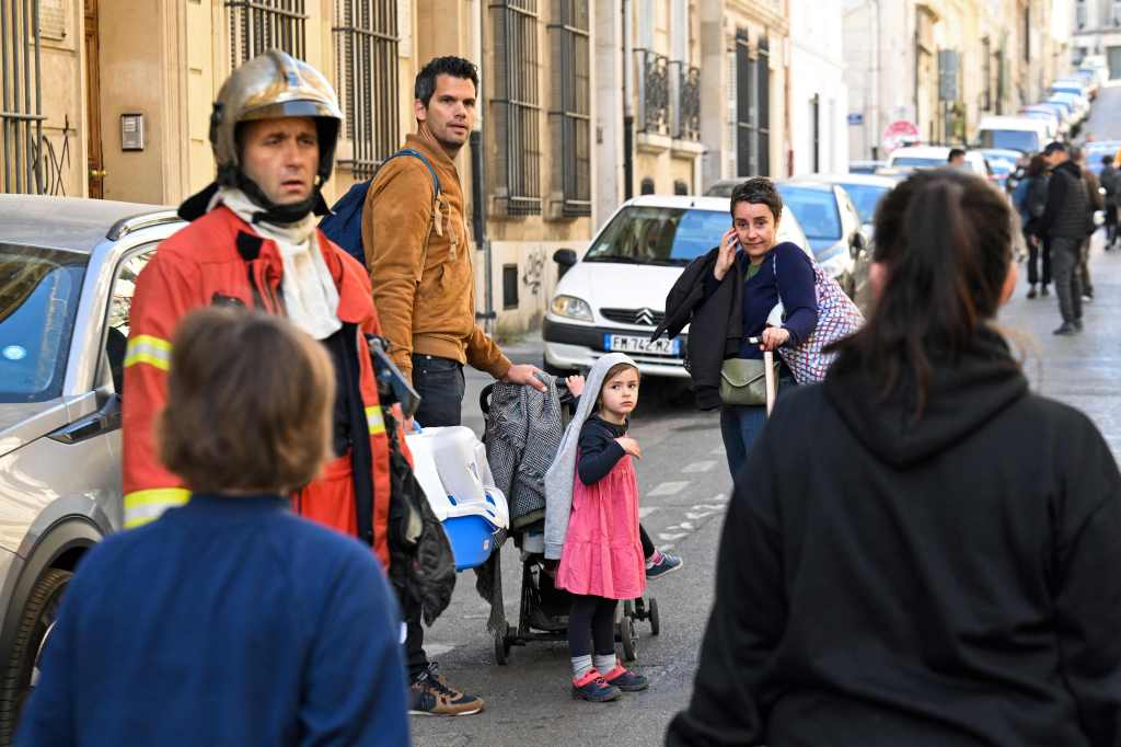 Families walk as inhabitants of the 'rue Tivoli' are evacuated after a building collapsed.