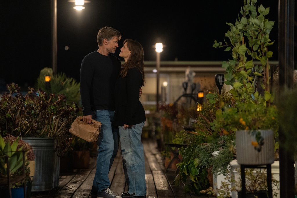 Nikolaj Coster-Waldau as Owen and Jennifer Garner as Hannah in "The Last Thing He Told Me," standing on a dock embracing, smiling at each other. 