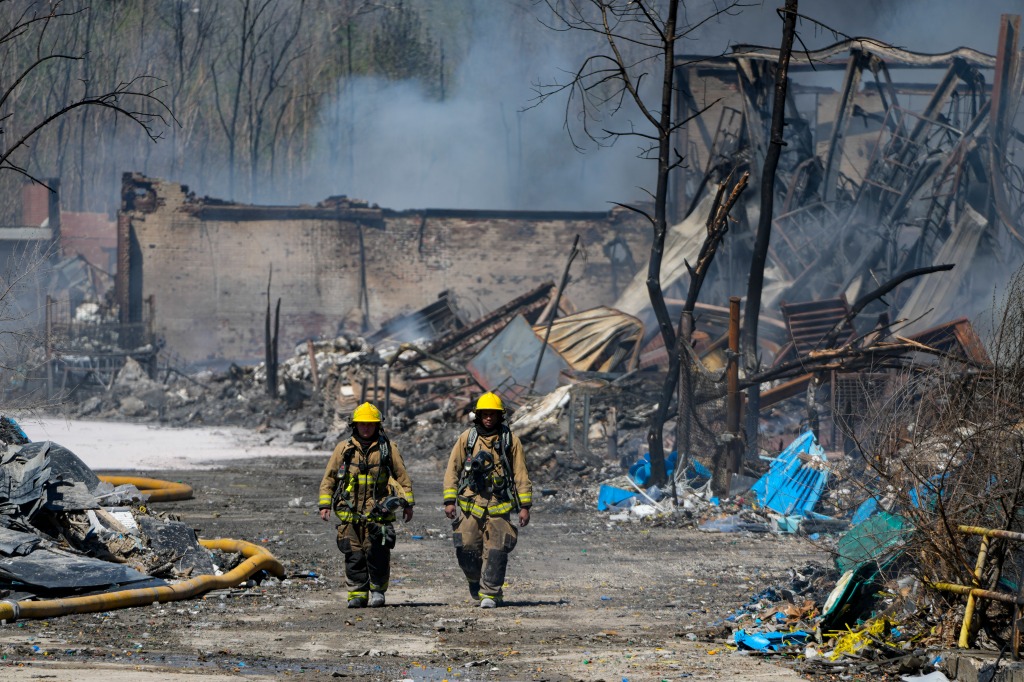 Firefighters walk out of the site of an industrial fire in Richmond.