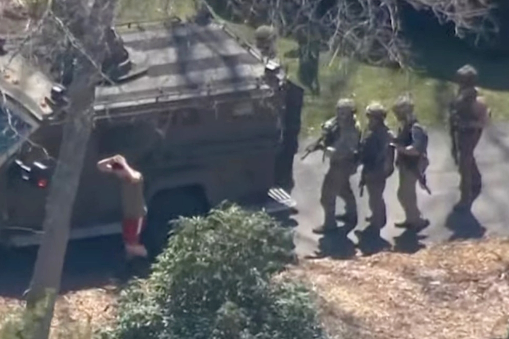 The guardsman is shown with his hands up as he's arrested