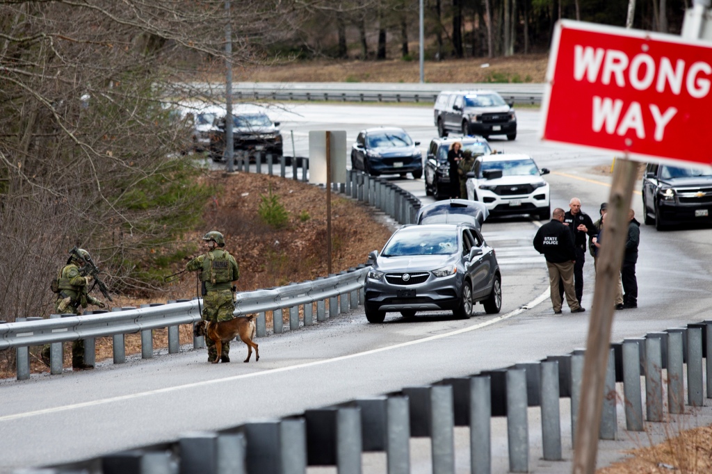 Members of law enforcement investigate a scene where people were injured in a shooting on Interstate 295, in Yarmouth, Maine, 