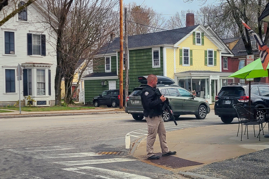 A police officer stands on the corner of Portland Street and Main Street in Yarmouth, Maine, 