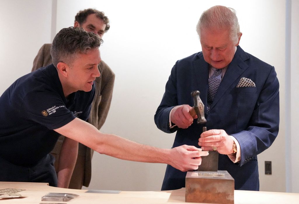 Britain's King Charles III hallmark's a piece of a Cross, commissioned by the Goldsmiths' Company on behalf of His Majesty The King when Prince of Wales, during his visit to The Goldsmiths' Centre in London, on November 23, 2022. (Photo by MAJA SMIEJKOWSKA / POOL / AFP) (Photo by MAJA SMIEJKOWSKA/POOL/AFP via Getty Images)