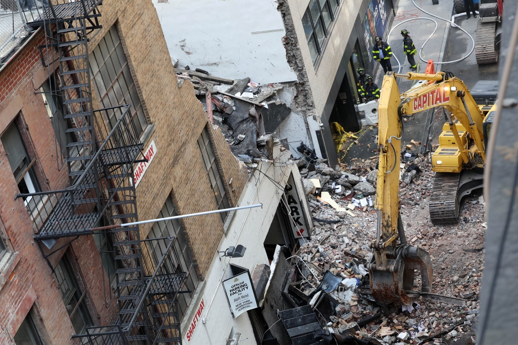 Workers removing debris from the facade of  the Ann Street parking garage collapse.