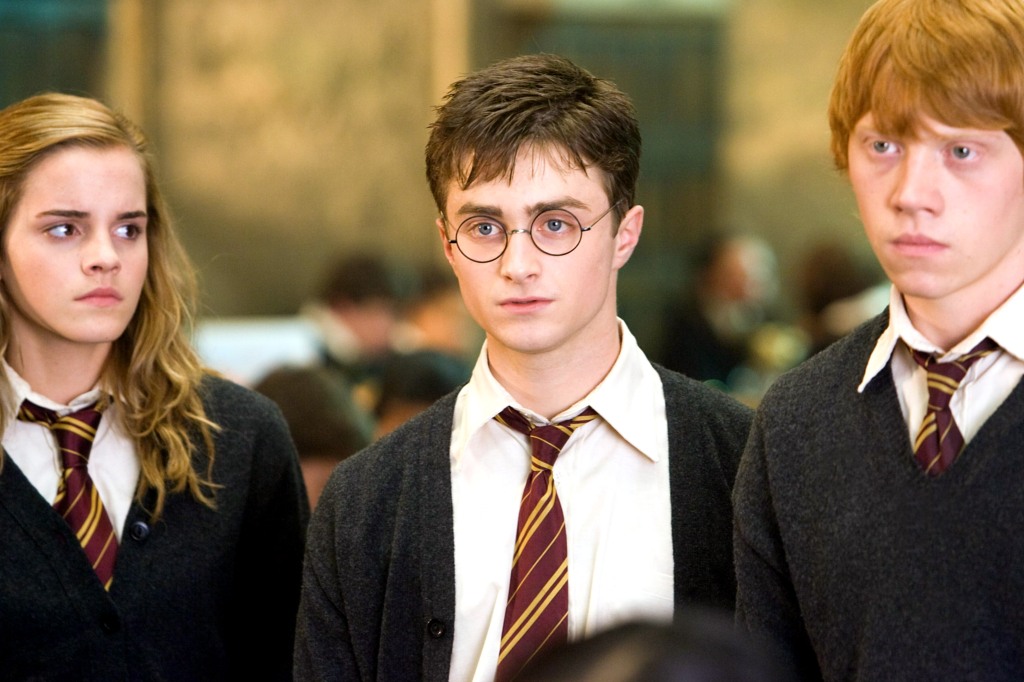 Hermione (Emma Watson), Harry (Daniel Radcliffe) and Ron (Rupert Grint) in "Harry Potter and the Order of the Phoenix." They stand in a line looking serious. 