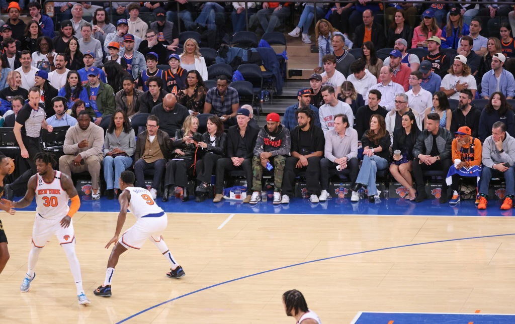 NBA Playoffs Game 3 - Cleveland Cavaliers vs. New York Knicks at Madison Square Garden - First Row (from left to right) Justin Tuck, his wife Lauran Williamson Tuck, Michael J. Fox, his wife Tracy Pollan, Patty Smith, John McEnroe, (right of red cap) J Cole, and spike Lee. Second row (left to right) Heidi Gardner, Cecily Strong, Kelvin Harrison Jr., Charles Melton, and Leon Robinson sit court side during the third quarter.