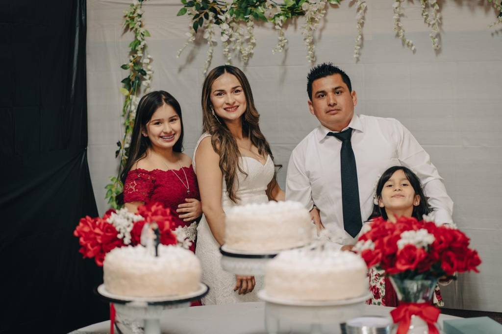 Two young girls stand alongside a bride and groom