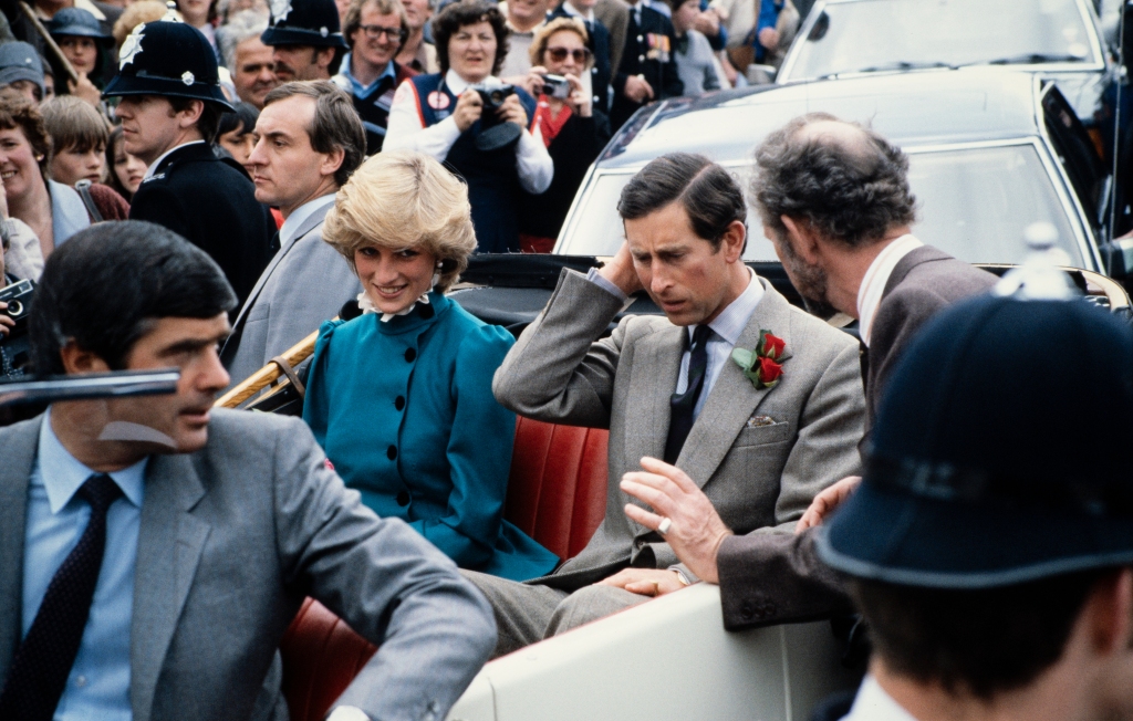 Prince Charles and Princess Diana in 1983. To Diana's left is bodyguard Barry Mannakee, sitting in a car in front of a crowd. 