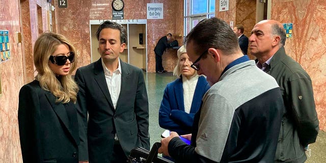 Khazar Momeni, left, stands in the Hall of Justice in San Francisco Friday, April 14, 2023, ahead of an appearance by her brother, Nima Momeni, who has been charged with murder in the death of tech entrepreneur Bob Lee. Khazar's husband, Dino Elyassnia, is to her right. Nima Momeni's arraignment was rescheduled to April 25, 2023, and he did not enter a plea. 