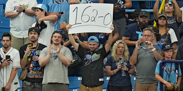 A Tampa Bay Rays fan holds up a sign during the ninth inning of the Oakland Athletics game on Sunday, April 9, 2023, in St. Petersburg.