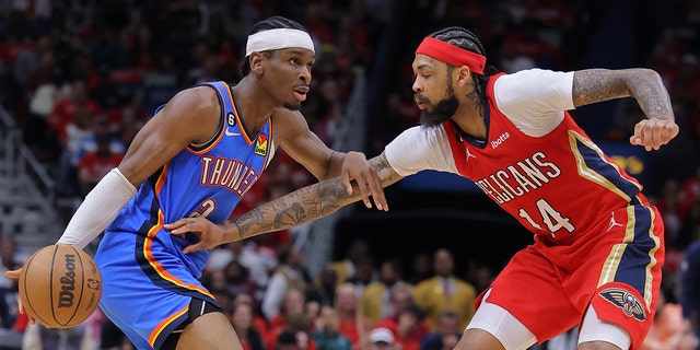 Shai Gilgeous-Alexander #2 of the Oklahoma City Thunder drives against Brandon Ingram #14 of the New Orleans Pelicans during the first half at the Smoothie King Center on April 12, 2023, in New Orleans, Louisiana. 