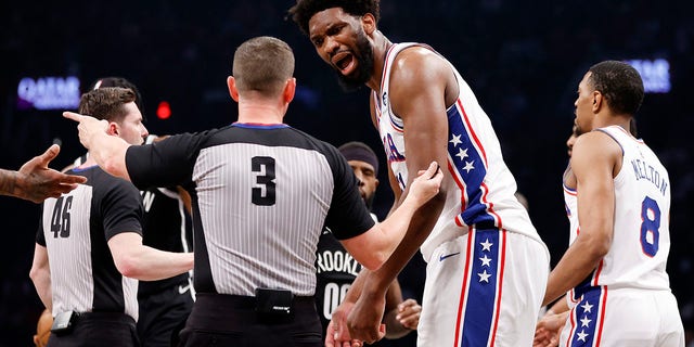 Joel Embiid talks to a referee