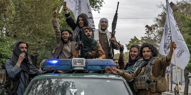 Taliban fighters celebrate one year since they seized the Afghan capital, Kabul, in front of the U.S. Embassy in Kabul, Afghanistan.