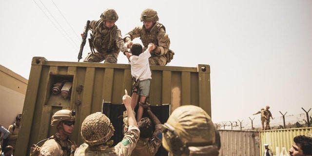 American troops are shown helping people to safety.