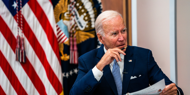 President Biden sitting in front of an American flag