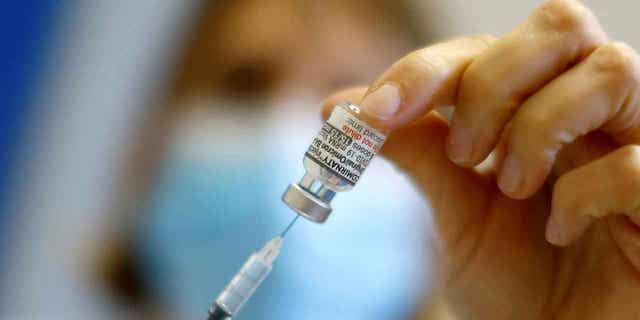 A medical worker prepares a dose of the "Cominarty" Pfizer-Bivalent coronavirus disease (COVID-19) vaccine at a vaccination center in Nice as a new surge in the COVID-19 outbreak starts in France, December 7, 2022. 