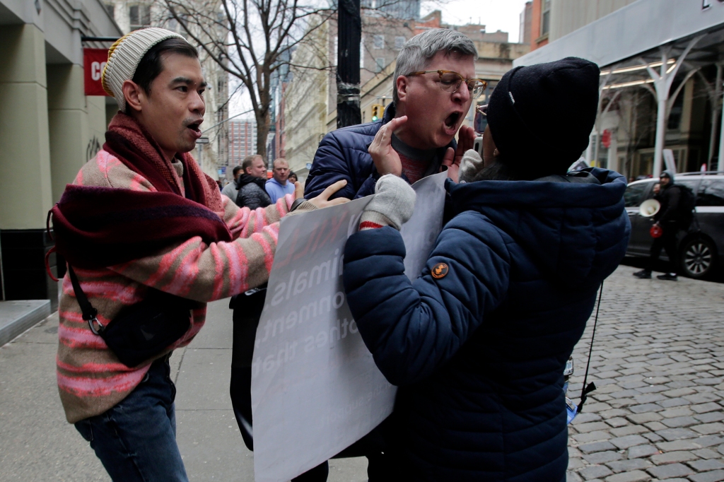  A man argues with an animal rights activist during a protest in front of Louis Vuitton on March 11, 2023 in New York City.