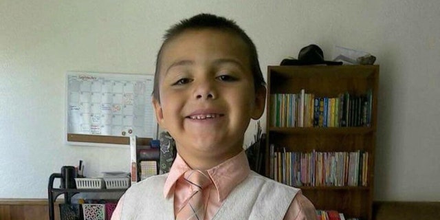 Anthony Avalos smiles in a tie and vest