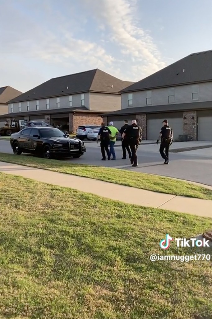 Sherland being escorted to patrol car.