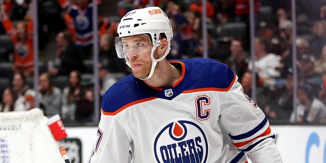 Connor McDavid #97 looks on after as assist to Ryan Nugent-Hopkins #93 of the Edmonton Oilers for an empty net goal during the third period of a game as Kevin Shattenkirk #22 of the Anaheim Ducks hits swings his stick in anger at Honda Center on April 05, 2023, in Anaheim, California. 