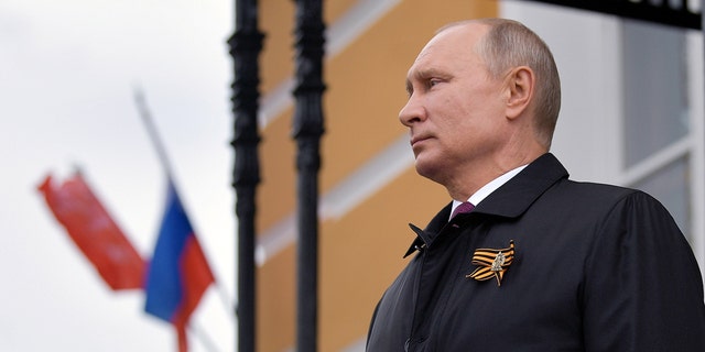 Russian President Vladimir Putin watches an air parade on Victory Day, which marks the anniversary of the victory over Nazi Germany in World War Two, amid the outbreak of the coronavirus disease (COVID-19) in central Moscow, Russia May 9, 2020.