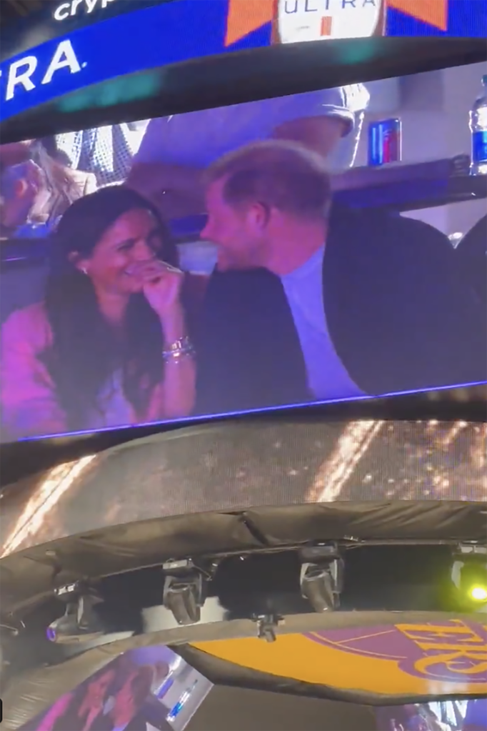 Footage shows Prince Harry and Meghan Markle turn and look at one another while Markle giggles. 
