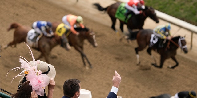 People react as they watch a horse race